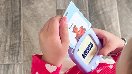 A toddler using the SmartKiddo Pocket Vocab learning toy to recognize and pronounce words, helping build confidence and early language skills