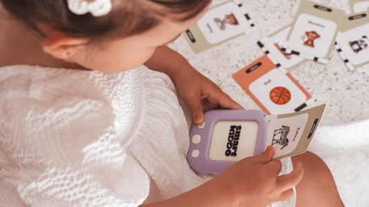A young child engaging with the SmartKiddo Pocket Vocab learning toy, using interactive flashcards to enhance early learning and cognitive development