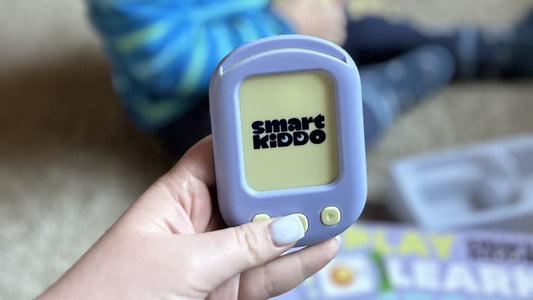 A hand holding the SmartKiddo Pocket Vocab learning toy, promoting screen-free interactive play for children to break the cycle of screen addiction