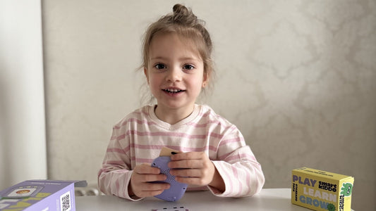 A happy young girl using the SmartKiddo Pocket Vocab learning toy, practicing pronunciation and speech development in a fun and engaging way